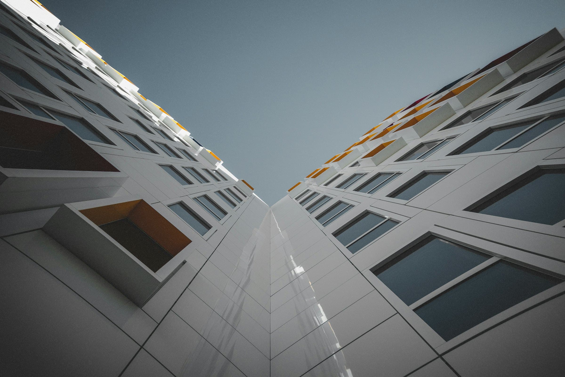White facade with repeating windows seen from below