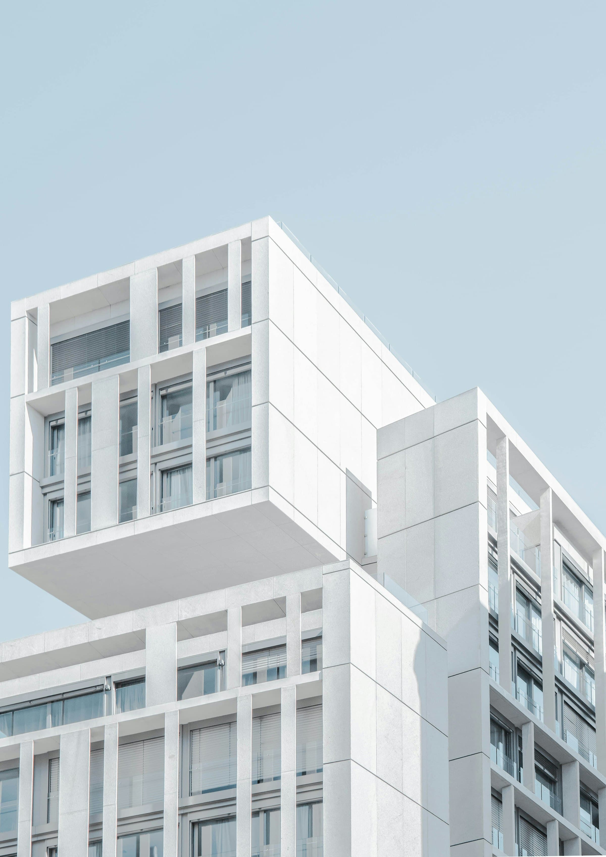 Stacked white residential high-rise with deep window reveals